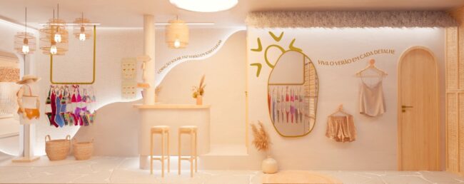 Interior da loja By Beach House com painéis de madeira, araras e espelho em arco